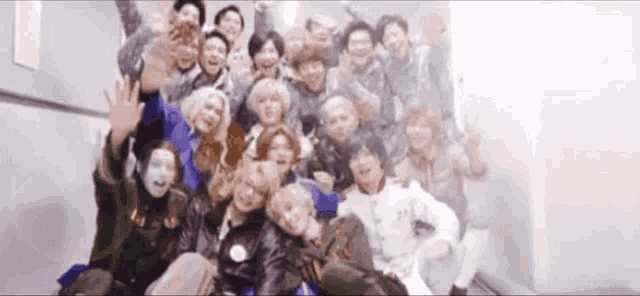 a large group of people are posing for a picture together in a room .