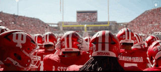 a group of indiana football players are huddled together on a field