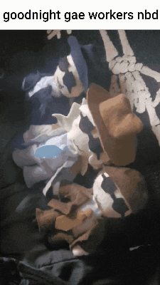 a bunch of stuffed animals are laying on top of a skeleton blanket