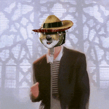 a man with a sombrero on his head sings into a microphone