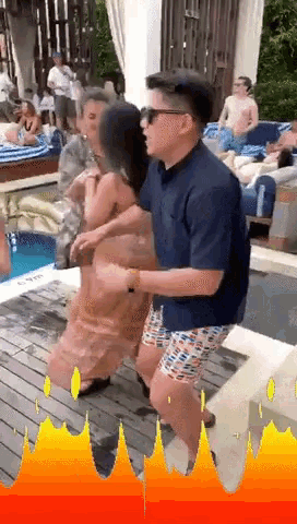 a man and a woman are dancing in front of a pool with a flame behind them that says fire