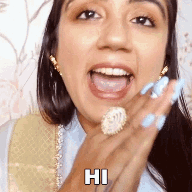 a woman with blue nails and a ring on her finger is making a funny face .