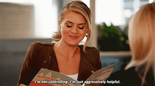 a woman is talking to another woman while holding a menu and saying i 'm not controlling