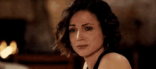 a close up of a woman 's face with a tear coming out of her eye .