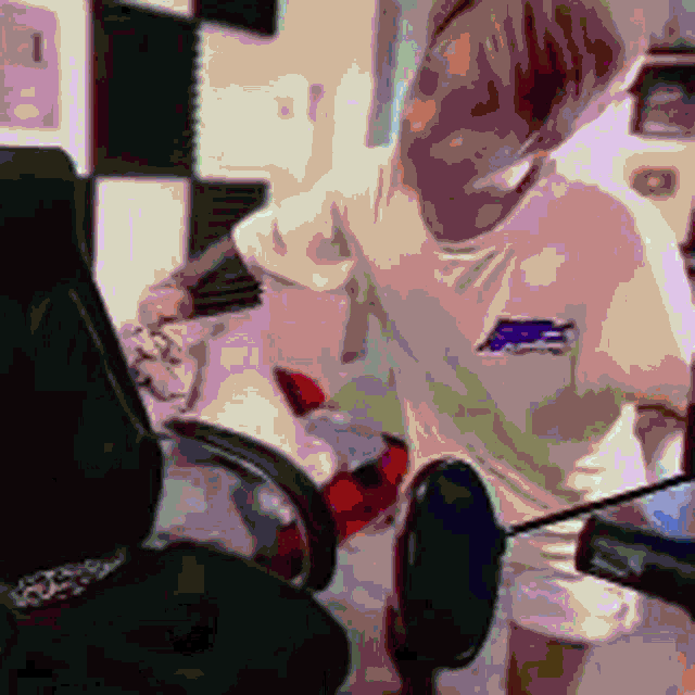 a man is sitting in a chair holding a controller and a microphone ..
