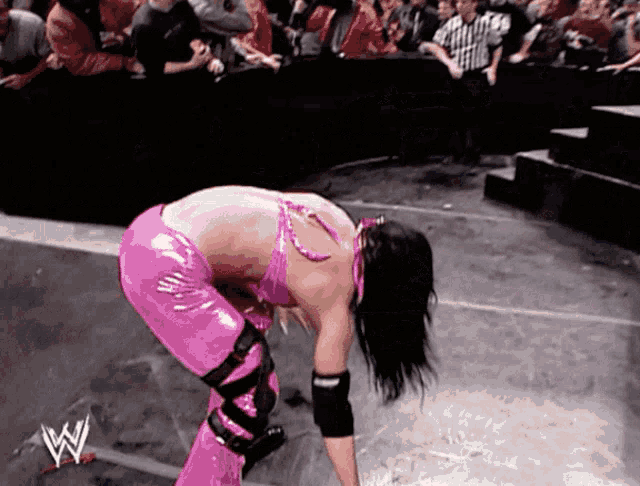 a female wrestler in a pink outfit with the letter w on the bottom right