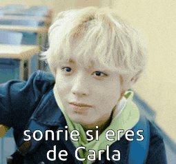 a boy with blonde hair is smiling with the words sonrie si eres de carla written below him