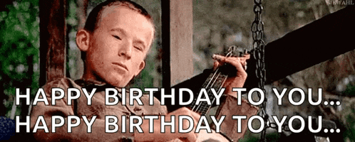 a young boy is sitting on a swing playing a guitar and says happy birthday to you ..