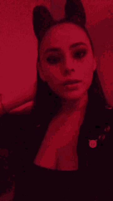 a woman with devil ears and a purple devil face on her chest