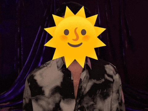 a man wearing a tie dye shirt has a sun on his face