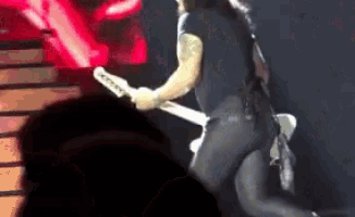 a man is playing a guitar on a stage