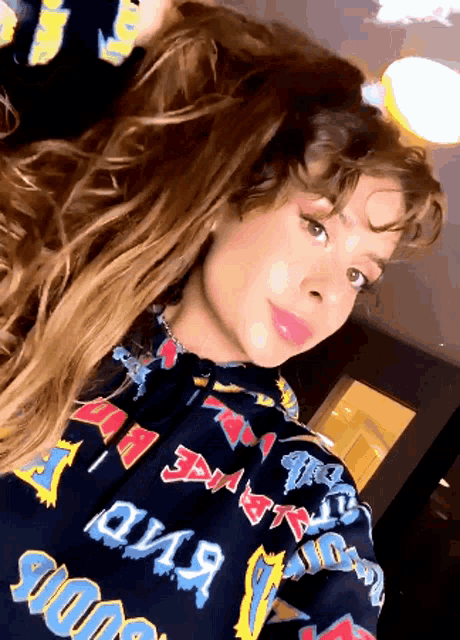 a woman wearing a hoodie that says ' over ' on it takes a selfie