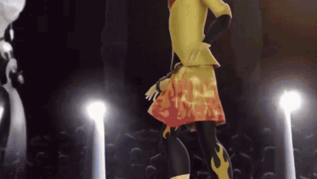a woman in a yellow jacket and orange skirt is dancing on a stage