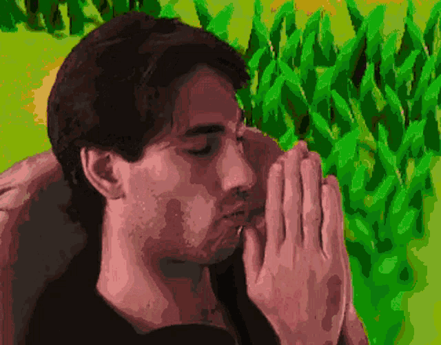 a pixelated image of a man praying in front of a field of green plants