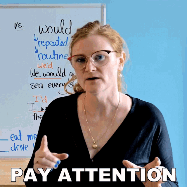 a woman stands in front of a whiteboard that says pay attention on it