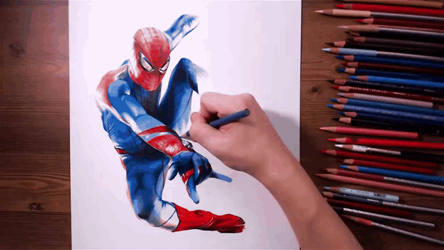 a person is drawing a spiderman with colored pencils on a table