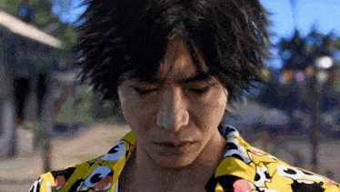 a close up of a man 's face wearing a yellow shirt