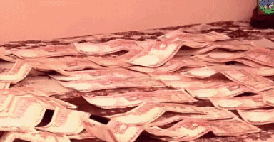 a pile of money is on a table with a clock in the background