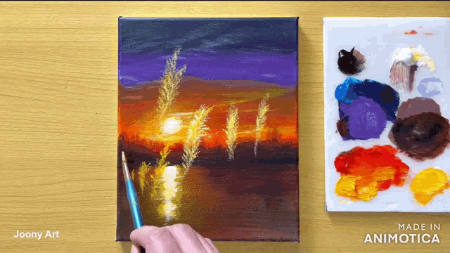 a painting of a sunset by joony art is being painted on a canvas