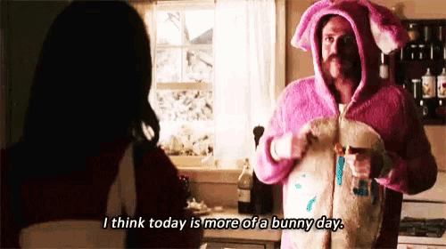a man in a pink bunny costume is talking to a woman