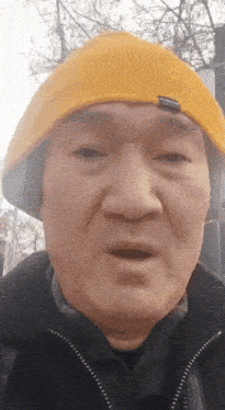 a man wearing a yellow hat and headphones is making a surprised face
