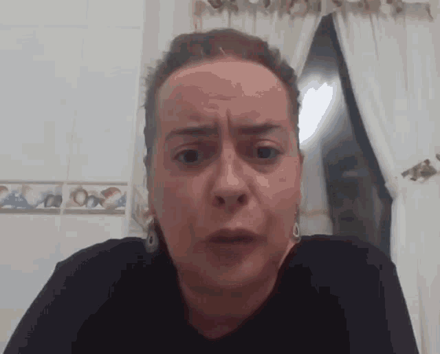 a woman in a black shirt looks at the camera