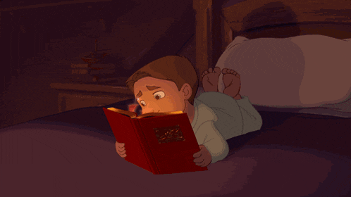 a little boy is laying on a bed reading a book called the bible