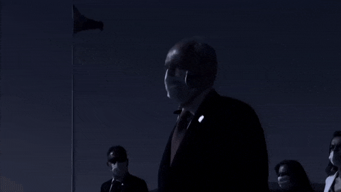 a man in a suit and tie wearing a face mask