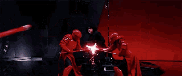 a man in a red suit is holding a red lightsaber and fighting another man with a red lightsaber .