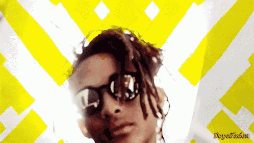 a man with dreadlocks wearing sunglasses is against a yellow and white background that says dopefader