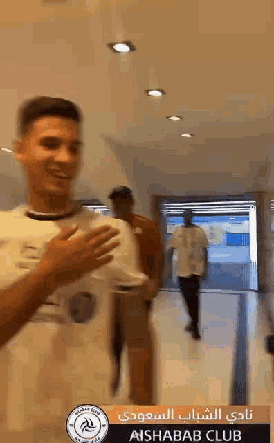 a man in a white shirt with the word aishab club on it