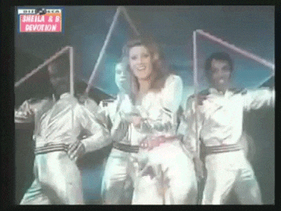 a group of people are dancing on a stage in front of a sign that says sheila rr devotion .