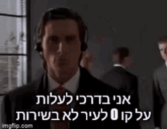 a man in a suit and tie is wearing headphones and talking to someone in another language .