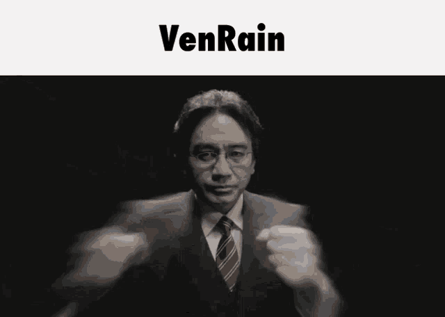 a man in a suit and tie stands in front of a banner that says venrain