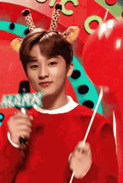 a young man wearing a giraffe headband and holding a microphone