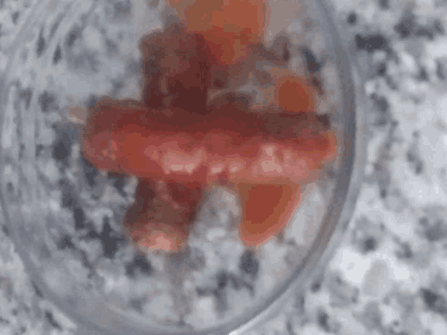 a close up of a sausage in a glass bowl on a counter .