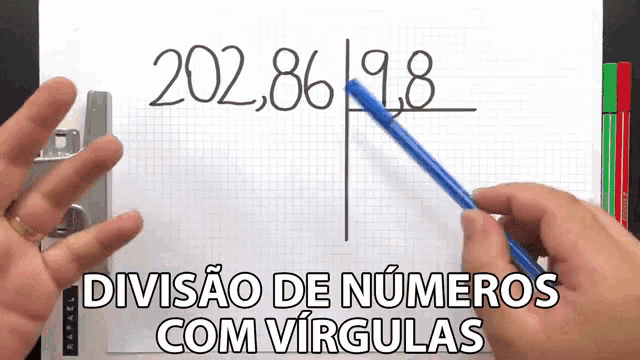 a person is holding a blue pen and pointing at the number 202.86