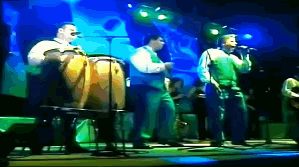 a group of people playing instruments and singing on stage