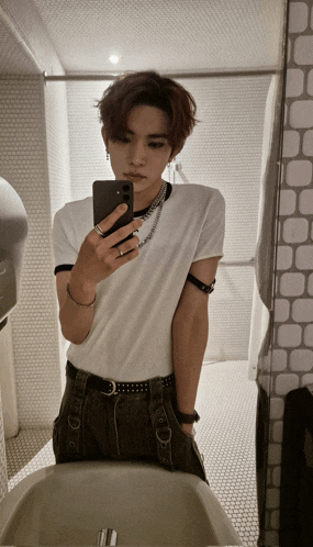 a young man taking a selfie in a bathroom