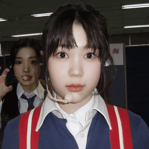 a girl with a microphone on her head is standing next to another girl