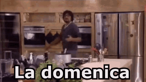 a man is cooking in a kitchen and the words la domenica are above him .