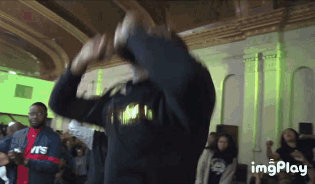 a man wearing a levis jacket is dancing in a crowd