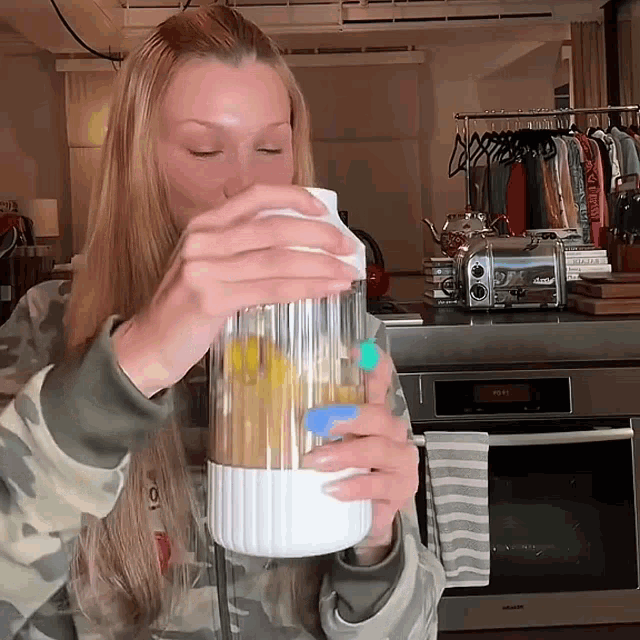 a woman in a camo sweatshirt is pouring something into a container with a blue lid