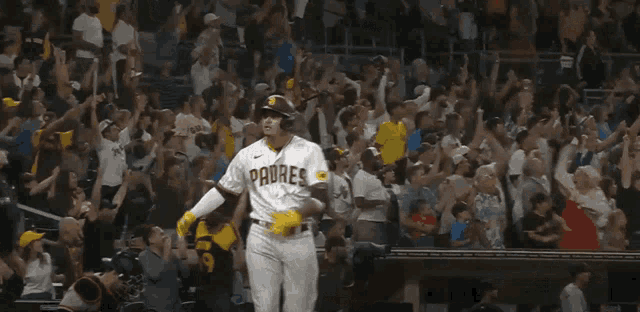 a padres baseball player stands in front of a crowd of people