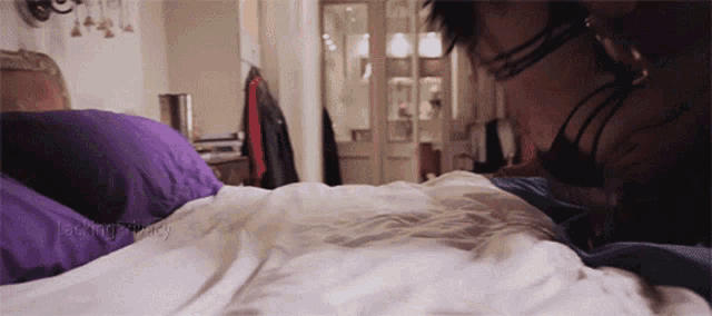 a woman is laying on a bed with a purple pillow and the words jack and tracy on the bottom right