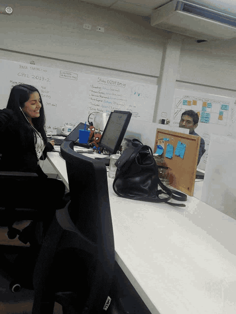 a woman sits at a desk in front of a white board that says " share distribution "