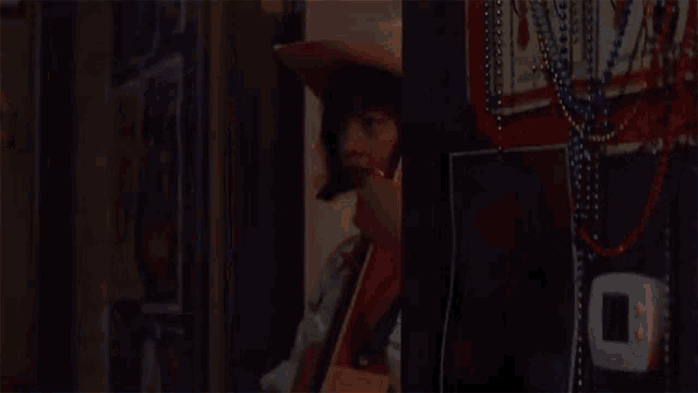 a woman in a cowboy hat is holding a guitar in her hand