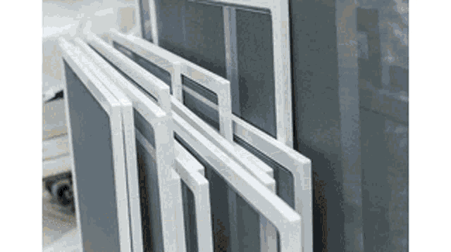 a bunch of white frames are stacked on top of each other on a table .