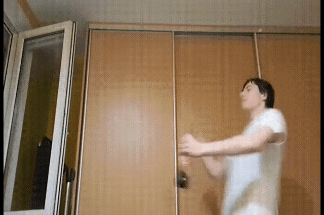 a man in a white shirt is jumping in the air