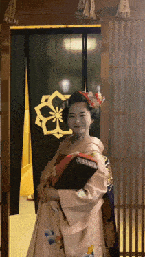 a woman in a kimono stands in front of a green curtain
